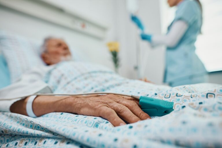 Close up of senior patient with pulse oximeter on finger in the hospital.